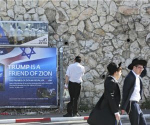 Ultra-Orthodox Jews pass by a billboard welcoming President Donald Trump ahed of his visit in Jerusalem